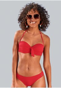 Rød bikini-sett med en knyttet bandeau-topp med justerbare stropper og en matchende lavsplittet bunn, begge i et teksturert stoff.