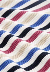 Stoff mit einem Wellenmuster in abwechselnden Streifen von Rosa, Blau, Beige, Schwarz und Weiß, mit einer gerippten Textur. 