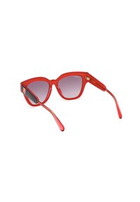Gafas de sol rojas de forma de ojo de gato con un acabado brillante, lentes degradados y acentos negros en las patillas. Presenta un detalle del logo en oro en el marco.