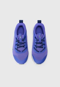 Lila Sportschuhe aus Mesh-Stoff mit Nylon-Akzenten und runden Zehen. Sie verfügen über blaue Schnürsenkel und ein kleines grünes Logo nahe der Ferse.