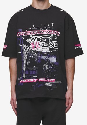 Czarna oversize'owa koszulka z bawełny, z wielokolorowymi grafikami oraz napisem "Pegador Most Alive" w różowym i fioletowym.