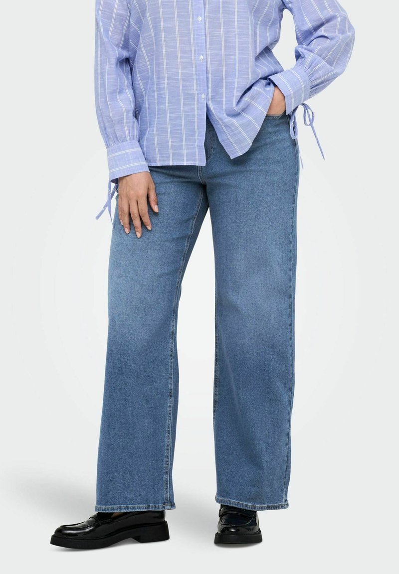 Light blue denim wide-leg jeans with a high waist, featuring a clean finish and subtle stitching details, paired with black shoes.