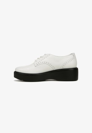Witte leren oxford schoenen met een dikke zwarte platformzool, voorzien van decoratieve perforaties langs de randen en ronde veters.