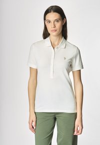 Polo shirt bianco realizzato in tessuto leggero, con colletto, tre bottoni e maniche corte. Include un piccolo logo ricamato.