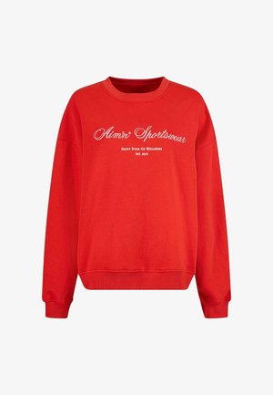 Piros pulcsi hosszú ujjal, kerek nyakkal, bordázott mandzsettával és hem. Fehér szöveggel díszítve: "Aim'n Sportswear" és "Daily Dose Of Wellness."