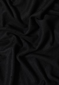 Tejido negro texturizado con una superficie suave y acanalada, que presenta pequeños acentos brillantes en forma de cuentas esparcidos por toda su extensión.