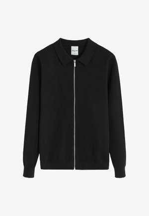 Gilet noir avec col arrondi, manches longues et fermeture éclair à l'avant. Fabriqué en matériau tricoté texturé, avec un design épuré.