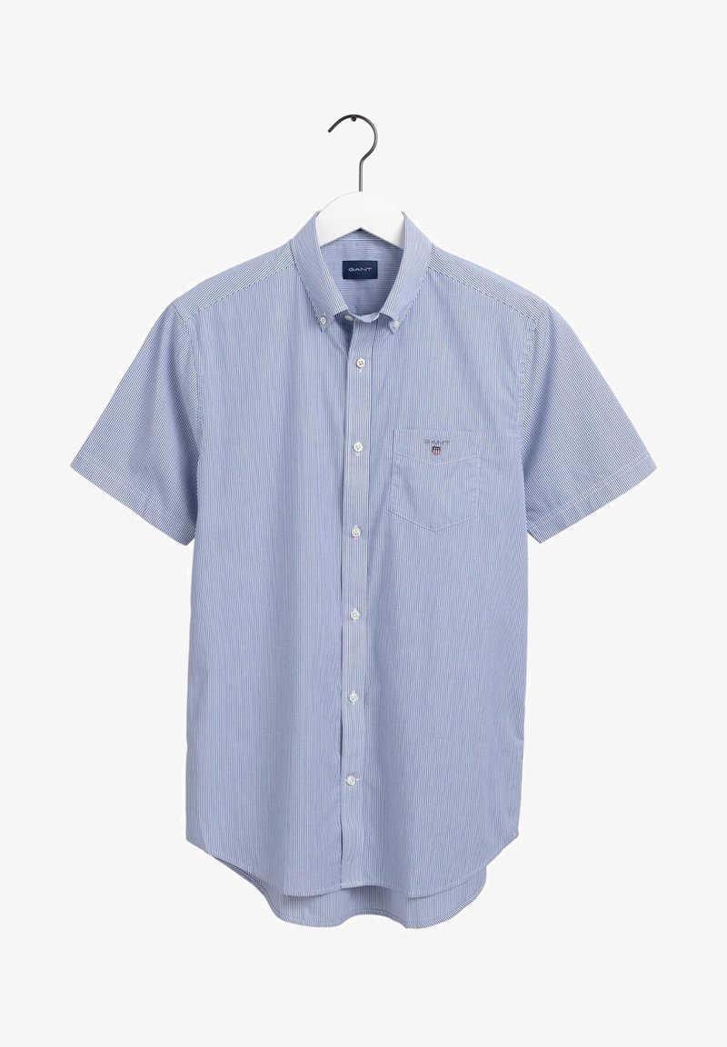 Chemise homme bleu clair à manches courtes avec fines rayures blanches, poche poitrine et col boutonné, accrochée sur un cintre blanc.