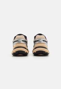 Sneakers da uomo, con parte superiore in mesh beige, dettagli neri, dettagli in argento e una suola intermedia testurizzata di crema con suola esterna nera a motivi.