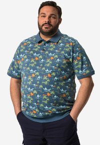 Poloko s krátkým rukávem v modrém bavlněném provedení, s barevným vzorem palm, velbloudů a hor v zelených a oranžových tónech, s límečkem.