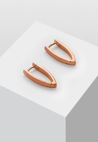 Boucles d'oreilles en métal rose doré avec une forme triangulaire allongée et une surface polie. Présentent une fermeture à charnière pour un port sécurisé.