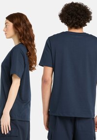 Navyblaue Baumwoll-T-Shirt mit kurzen Ärmeln, rundem Ausschnitt und geradem Schnitt. Verfügt über ein Etikett auf der unteren linken Seite.