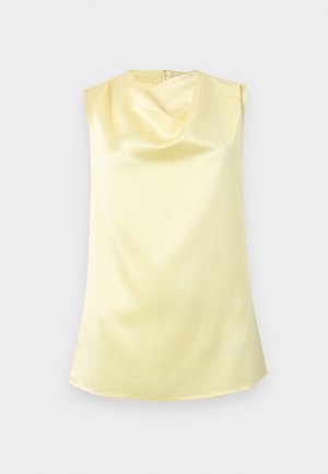 Bezrukavna blago žuta satenska bluza s naboranim izrezom kapuljače i patentnim zatvaračem na leđima, na bijeloj pozadini.