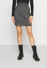 Gonna grigia con texture, con elastico in vita, di lunghezza al ginocchio, abbinata a stivali combat neri con design allacciato e dettagli in fibbia.