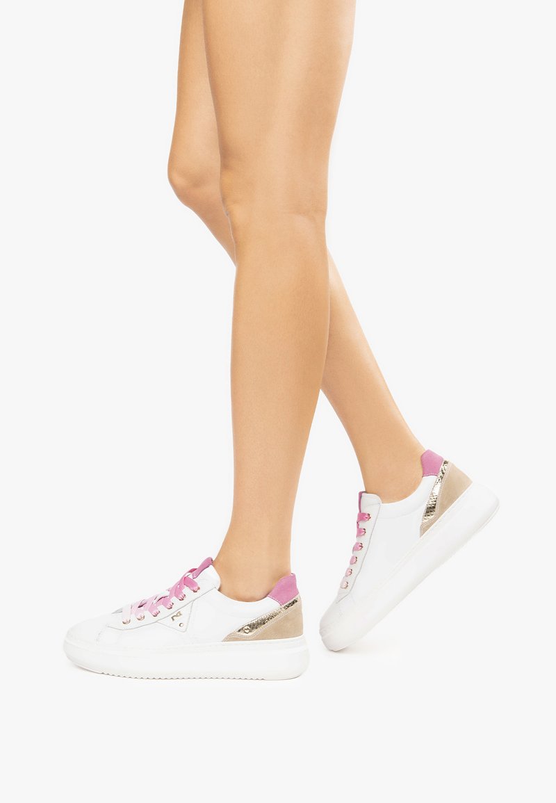 Sneakers bianchi con lacci e dettagli rosa, particolari metallici dorati sul tacco e una texture liscia. Suola piatta e design low-top.