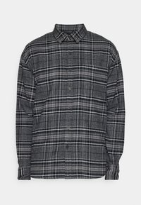 Camisa de franela a cuadros grises con mangas largas, cierre de botones en la parte delantera y un cuello estructurado. Presenta patrones de cuadros alternando entre oscuro y claro.
