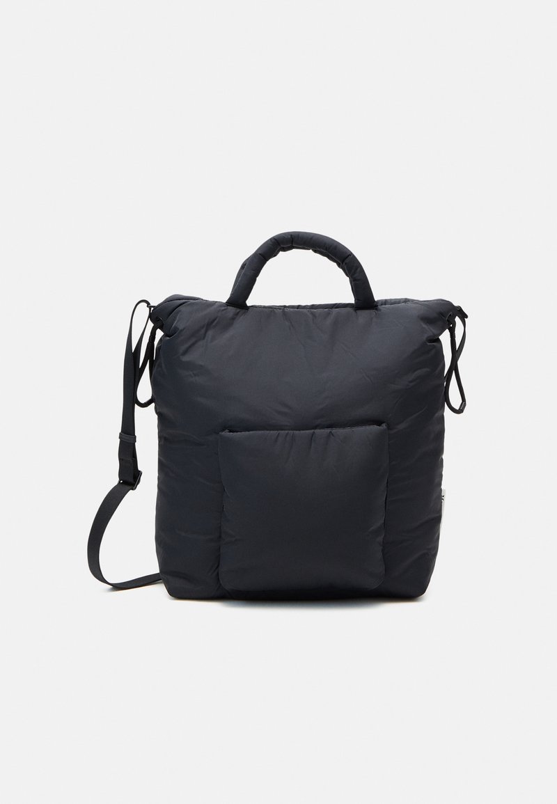 Sac à dos matelassé noir avec un compartiment principal spacieux, des poignées rembourrées, une poche avant et une sangle d'épaule réglable. Texture lisse.