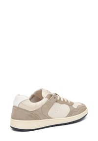 Baskets avec un dessus en daim et cuir beige et crème, avec une finition texturée, des lacets plats et une semelle en caoutchouc pour l'adhérence.