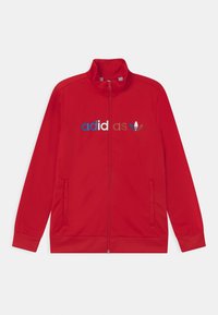 Červená bunda na zip vyrobená z hladké tkaniny, s vysokým límcem, bočními kapsami a vícebarevným logem "adidas" s emblémem.
