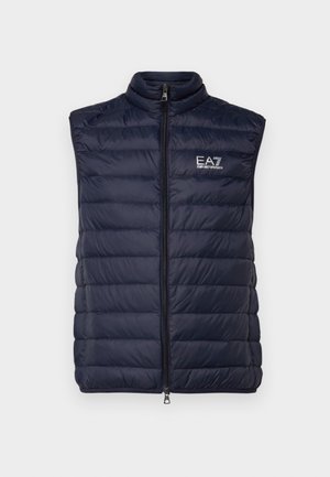 Navy blue puffer vest with a high collar, vertical quilted design, and zip closure, featuring a logo on the left chest.