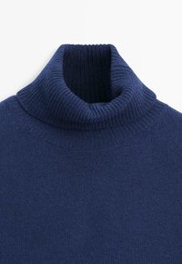 Maglione a collo alto a coste blu navy con tessuto spesso e morbido a maglia e dettaglio del colletto ripiegato.