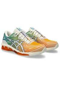 Colorful running shoes featuring a gradient design from green to orange, mesh upper, white accents, and a cushioned, orange outsole.