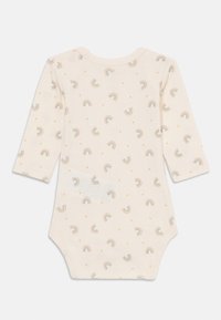 Krämfärgad långärmad bodysuit med ett regnbågs- och prickmönster; mjukt tyg, rund hals, tryckknappsstängning nertill för enkel påklädnad.