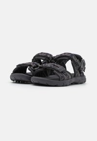 Black athletic sandals with adjustable fabric straps, textured surface, and a durable rubber sole featuring a patterned design.