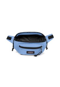 Modrý látkový ledvinka s černým interiérem, se zipovými přihrádkami, nastavitelnými popruhy a našitou značkovou nášivkou na přední straně.