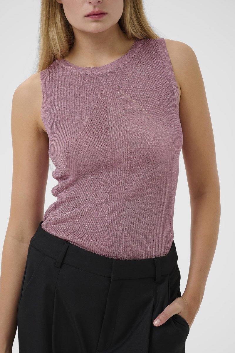 Sleeveless top in light pink ribbed knit fabric, featuring a subtle geometric pattern and round neckline, paired with black trousers.