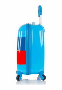 Maleta rígida azul con un acabado brillante, que presenta patrones geométricos coloridos en rojo, amarillo y azul. Mango retráctil y ruedas.