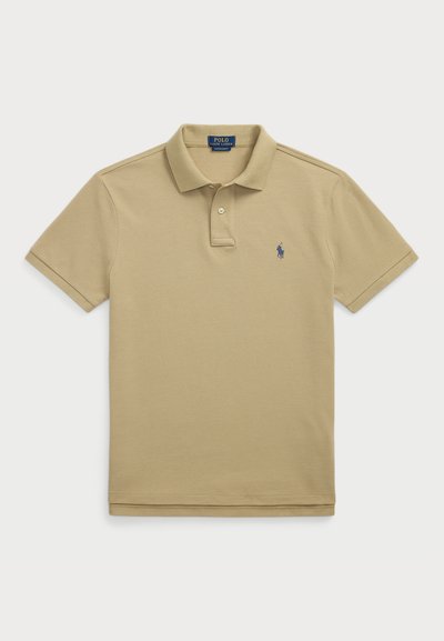 Khaki polo särk klassikalise kraega, lühikeste varrukatega ja ühe nupuga nööppluus. Vasakul rinnal on väike mereväe sinine logo.
