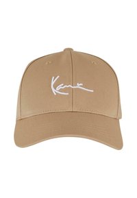 Cappellino da baseball beige in cotone con visiera curva, caratterizzato da dettagli ricamati bianchi sulla parte anteriore.