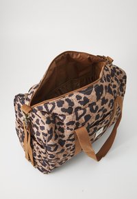 Borsone con stampa leopardata marrone e nera, con chiusura a zip, manici in tessuto e un ampio interno foderato in marrone. Presenta una tasca laterale.
