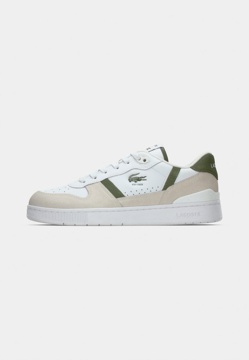 Baskets basses blanches et beige avec des accents verts, bouts perforés, fermeture à lacets, et logo crocodile Lacoste sur le côté et le talon.