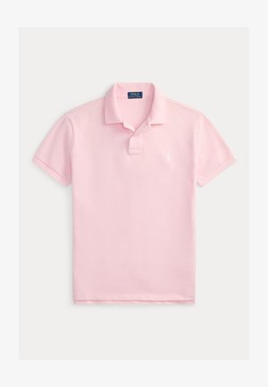 Svetlo roza polo majica s kratkimi rokavi, ovratnikom, dvema gumboma in majhnim vezenim logotipom na prsih, položena na ravno na belem ozadju.