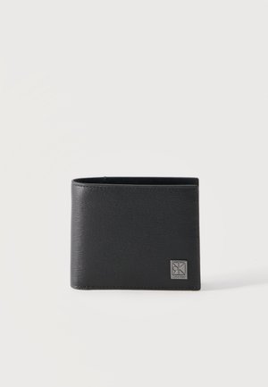 Portafoglio bifold in pelle nera texturizzata con targa del logo Calvin Klein in argento nell'angolo in basso a destra.