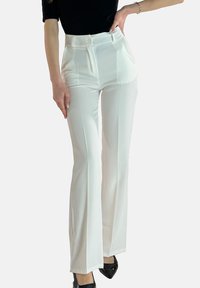 Vita utsvängda byxor med hög midja, utrustade med en enkel knappstängning och vertikala sömmar. Perfekta för formella eller affärsmässiga tillfällen.