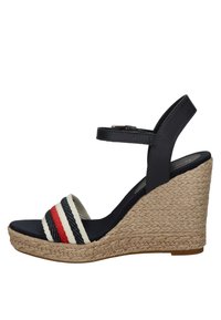 Sandal con tacco a cuneo con cinturino alla caviglia in pelle blu scuro, suola nera e suola in juta intrecciata; presenta un nastro di tessuto a strisce blu, bianco e rosso.