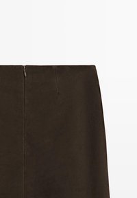 Dunkelbrauner Wildlederrock mit mittig platziertem Reißverschluss hinten und einem dezenten Nahtdetail vor weißem Hintergrund.