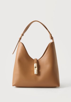 Borsa a tracolla in pelle color cammello con tracolla regolabile e chiusura a scatto in oro, mostrata su uno sfondo chiaro e uniforme.