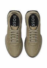 Beige lädersneakers med en texturerad yta, med runda snören, vadderad krage och gummisula. "BOSS"-logotyp på tungan och innersulan.