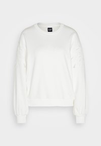 Bílá mikina s dlouhými rukávy, žebrovanými manžetami, uvolněným střihem a dekorativním výřezem na rukávech.