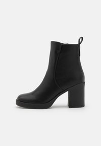 Stivaletto nero alla caviglia con punta arrotondata, realizzato in morbida ecopelle. Presenta una cerniera laterale e un tacco a blocco con texture.