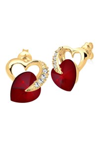 Boucles d'oreilles en forme de cœur en or ornées de cœurs en cristal rouge et de petits strass clairs sur un côté pour une touche d'éclat supplémentaire.