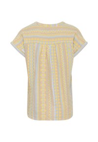 Kortärmad topp med en avslappnad passform, tillverkad av lättviktsmaterial. Har ett gult och blått geometriskt mönster på en beige bakgrund.