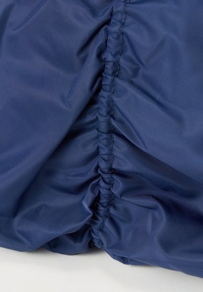 Υφασμα σε ναυτικό μπλε με ραφή που μαζεύει, δημιουργώντας ραφή με λούρεξ ελαστική λεπτομέρεια σε ελαφρύ υλικό.