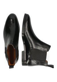Botas Chelsea de cuero negro con paneles laterales elásticos y tiradores, mostradas desde ángulos superior y lateral sobre un fondo blanco.