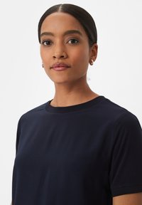 Marine Kurzarm-T-Shirt aus glattem Material mit rundem Halsausschnitt und subtilen Nahtdetails. Einfaches und vielseitiges Design.