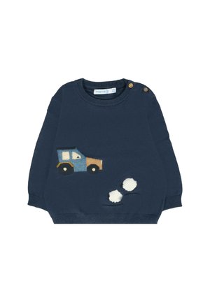 Maglione per bambino blu navy con applicazione di un camion marrone e blu e tre pompon bianchi attaccati vicino all'orlo, bottoni in legno sulla spalla.